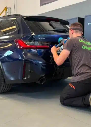Tecnico al lavoro sulla lucidatura di un'auto – Carrozzeria Cubicar Rovereto